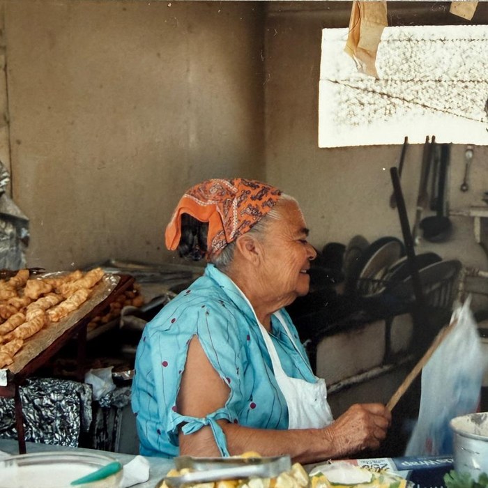 Tijuana, 1991: a smiling cook with an orange headscarf at her market stall